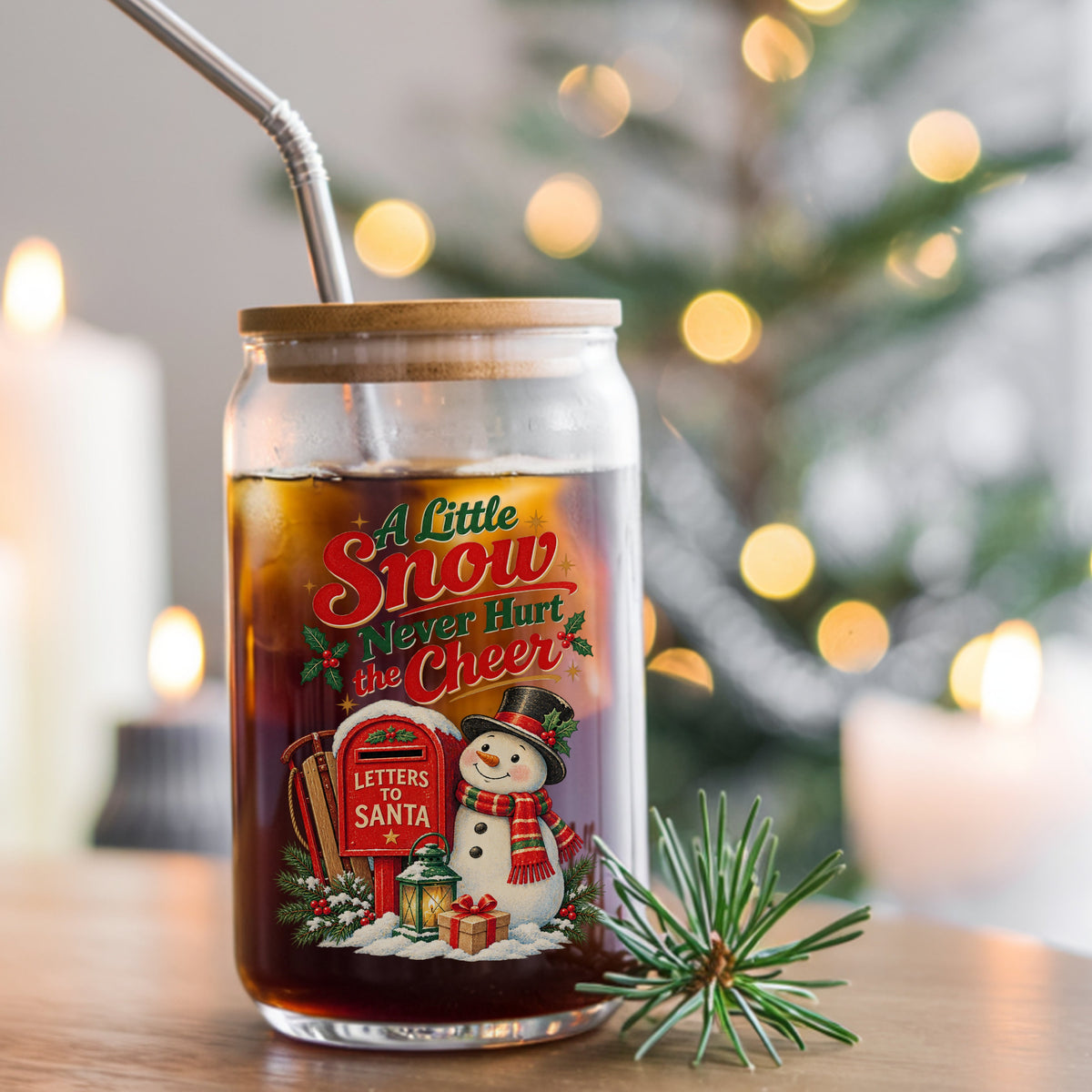 A Little Snow Never Hurt The Cheer Snowman UV DTF sticker applied to a glass can cup of iced coffee with a straw