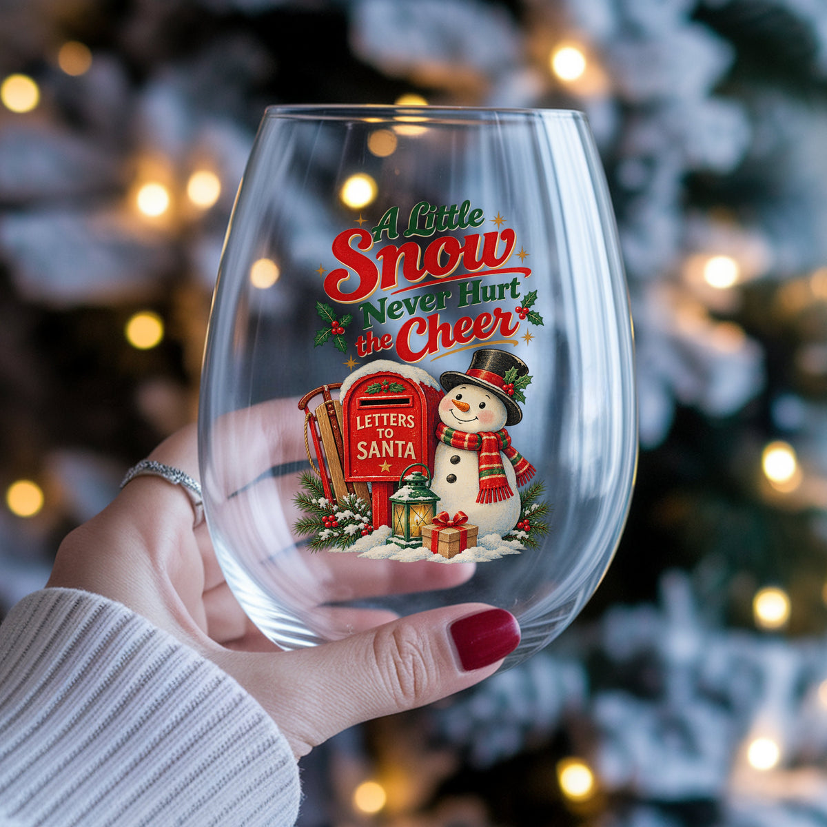 A Little Snow Never Hurt The Cheer Snowman UV DTF sticker applied to a stemless wine glass held in hand