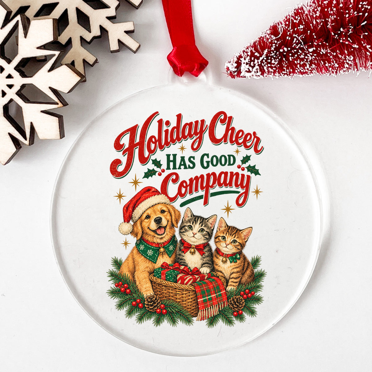 Holiday Cheer Has Good Company Puppy Kittens UV DTF sticker applied to a clear round acrylic ornament with a red ribbon