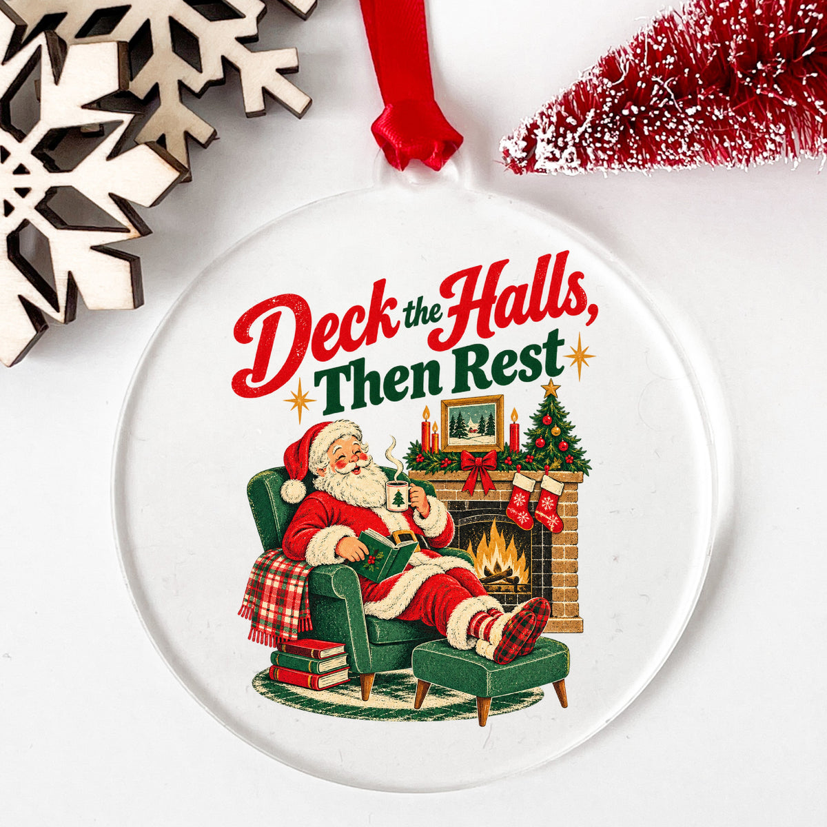 Deck The Halls Then Rest Santa UV DTF sticker applied to a clear round acrylic ornament with a red ribbon