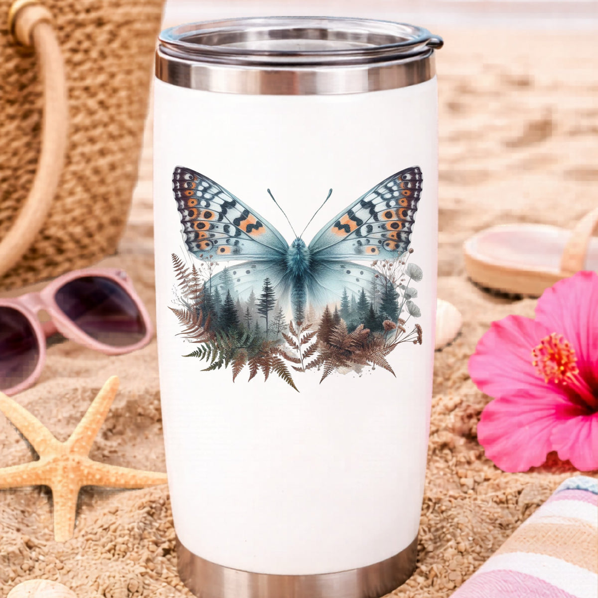Fern Butterfly UV DTF sticker applied to a white travel tumbler on beach sand