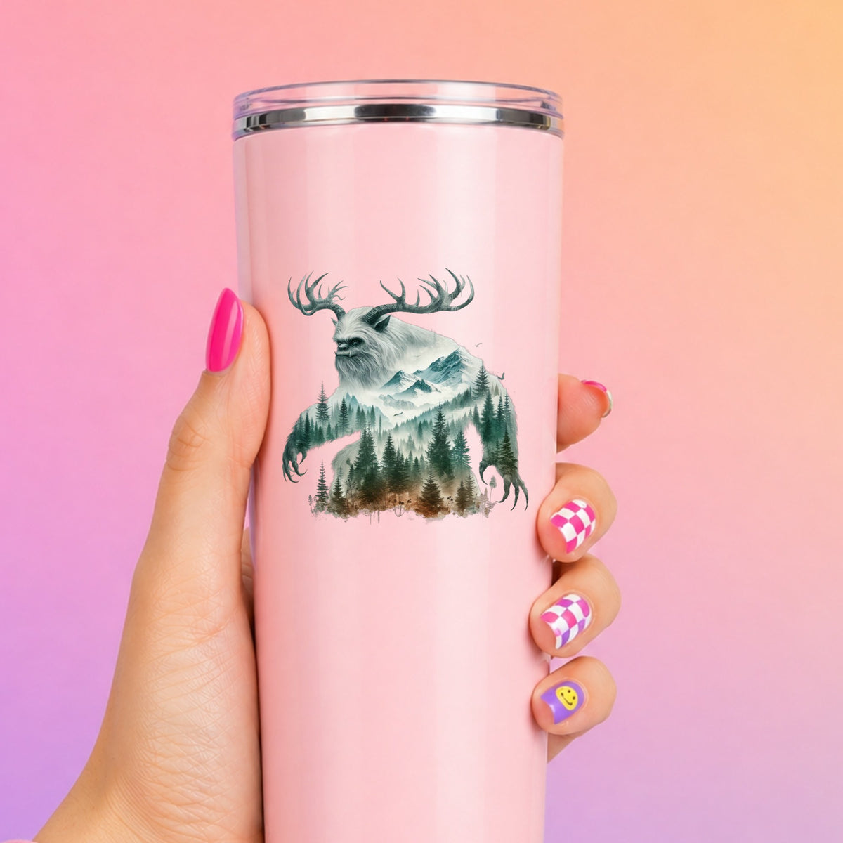 Antlered Mountain Bigfoot UV DTF sticker applied to a tall pink tumbler on a pink and orange background