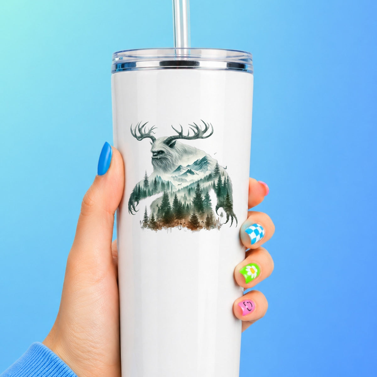 Antlered Mountain Bigfoot UV DTF sticker applied to a white straw tumbler on a blue background