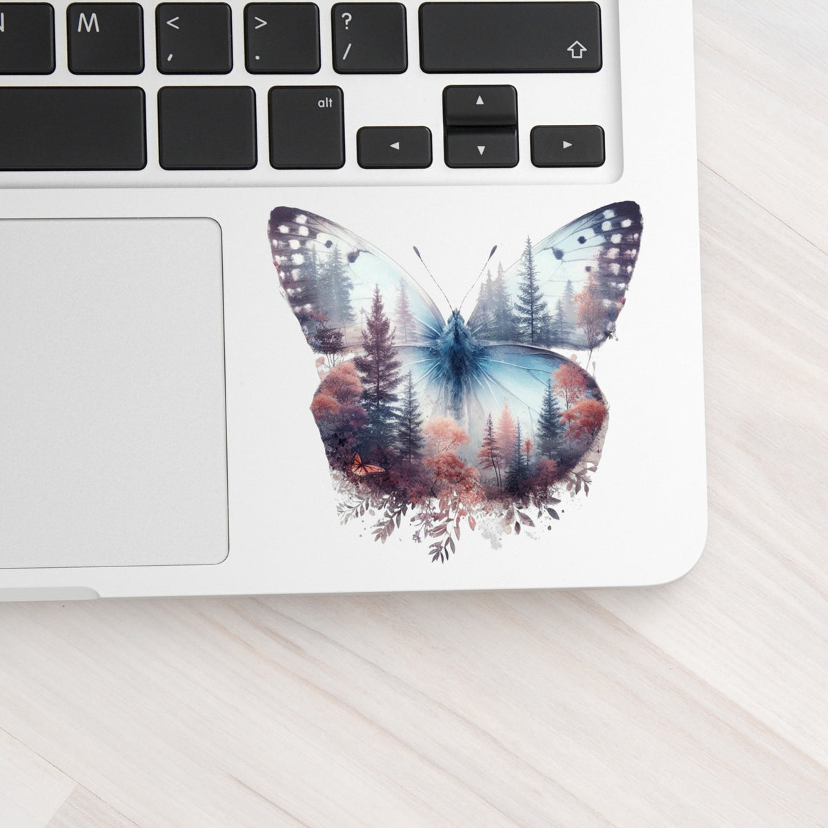Pink Forest Butterfly UV DTF sticker applied to a silver laptop beside the keyboard