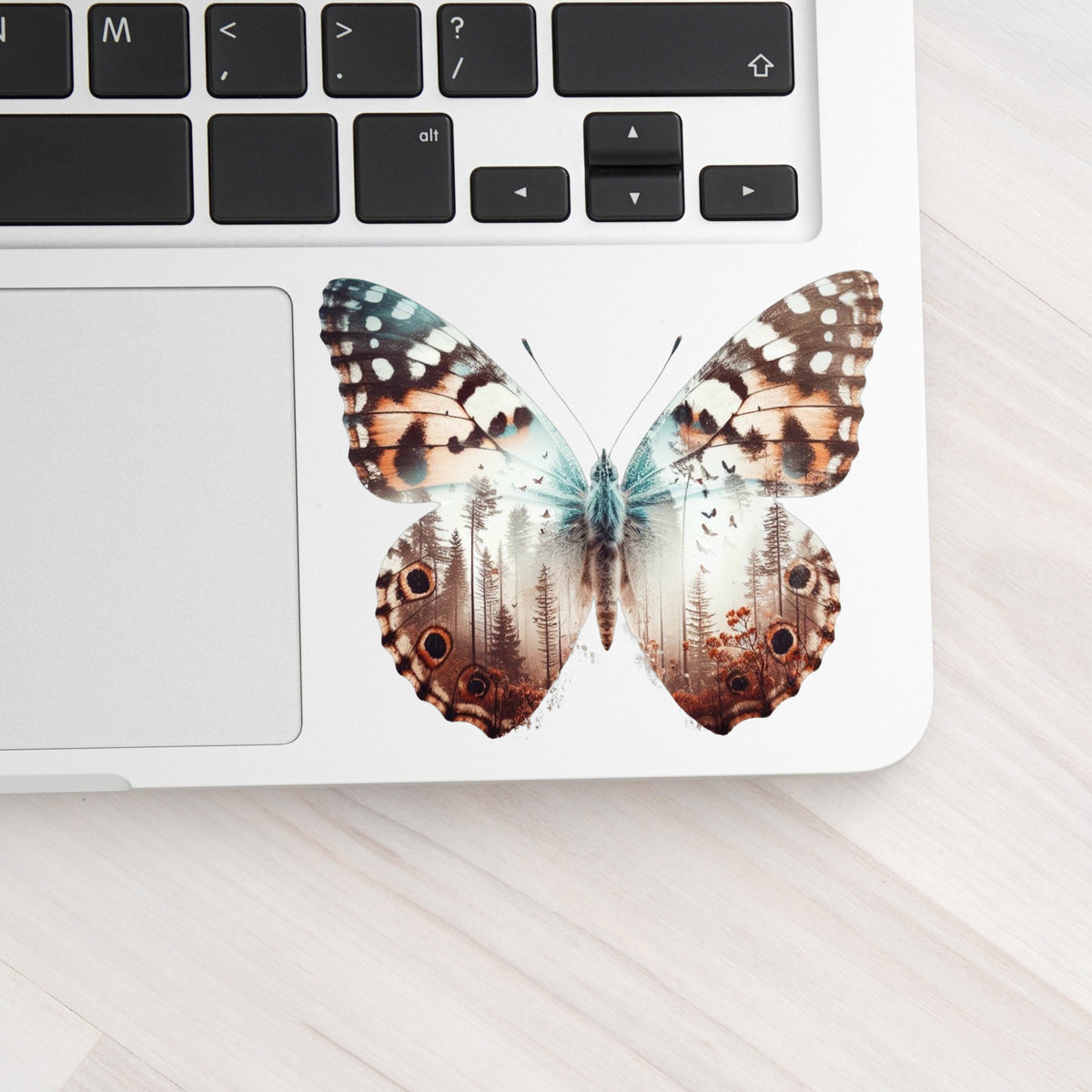 Rust Brown Butterfly UV DTF sticker applied to a silver laptop beside the keyboard