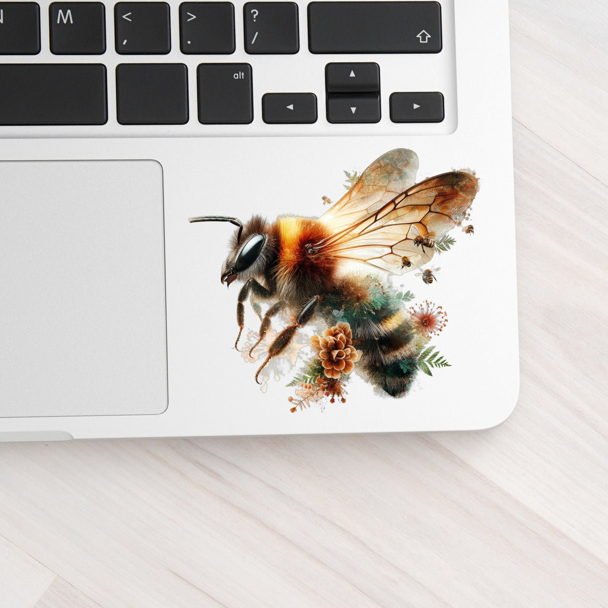 Pinecone Bumblebee UV DTF sticker applied to a silver laptop beside the keyboard