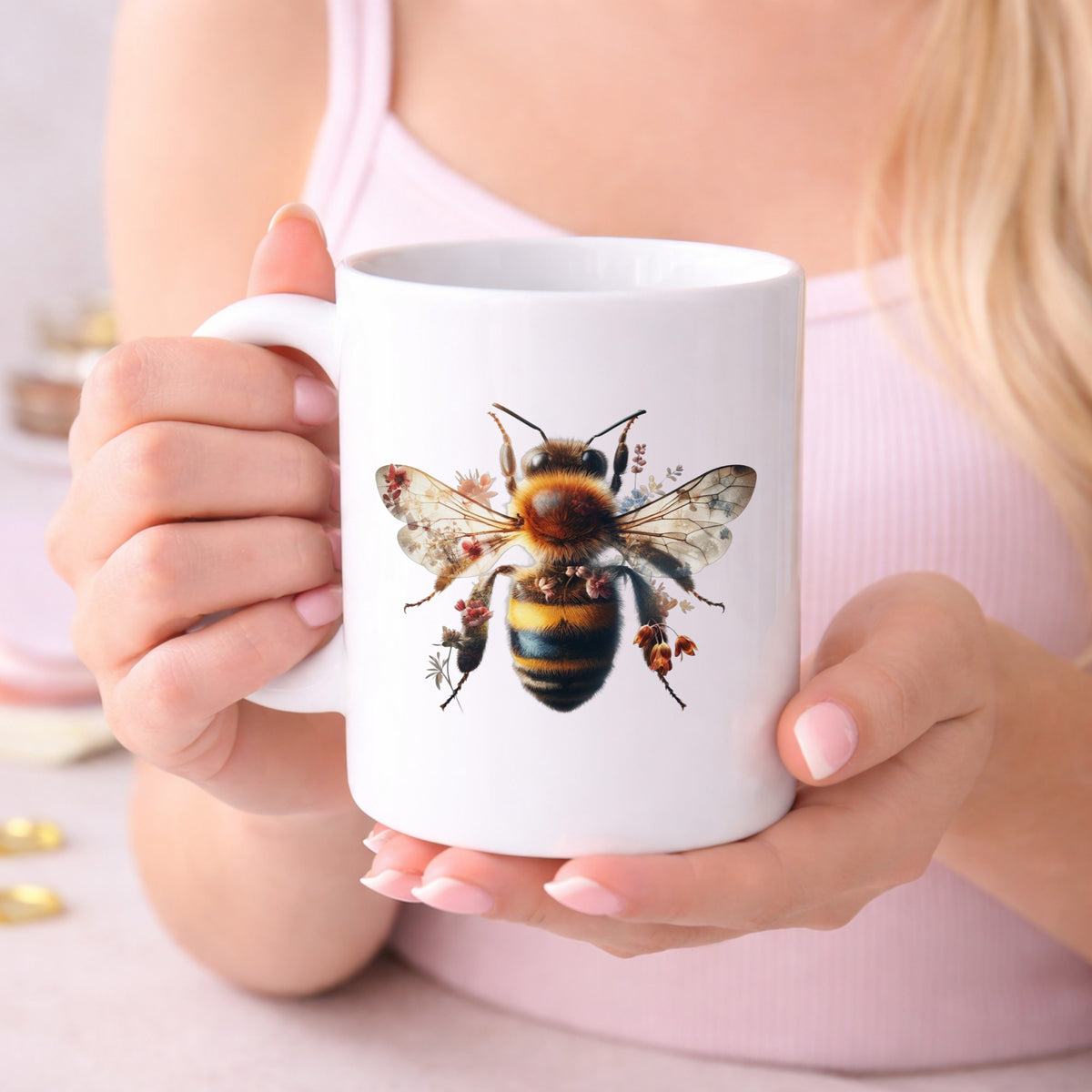 Pink Floral Bee UV DTF sticker applied to a white coffee mug held in both hands