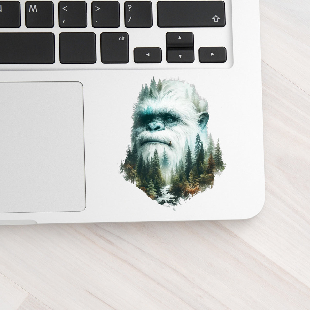 Bigfoot Face UV DTF sticker applied to a silver laptop beside the keyboard