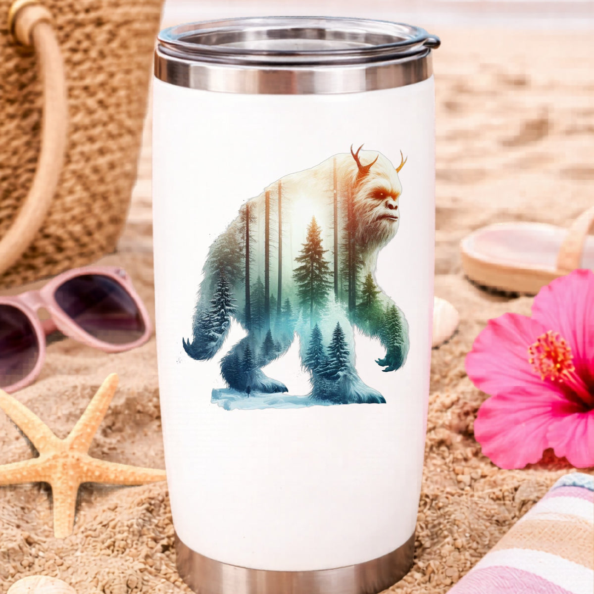 Walking Sasquatch UV DTF sticker applied to a white travel tumbler on beach sand