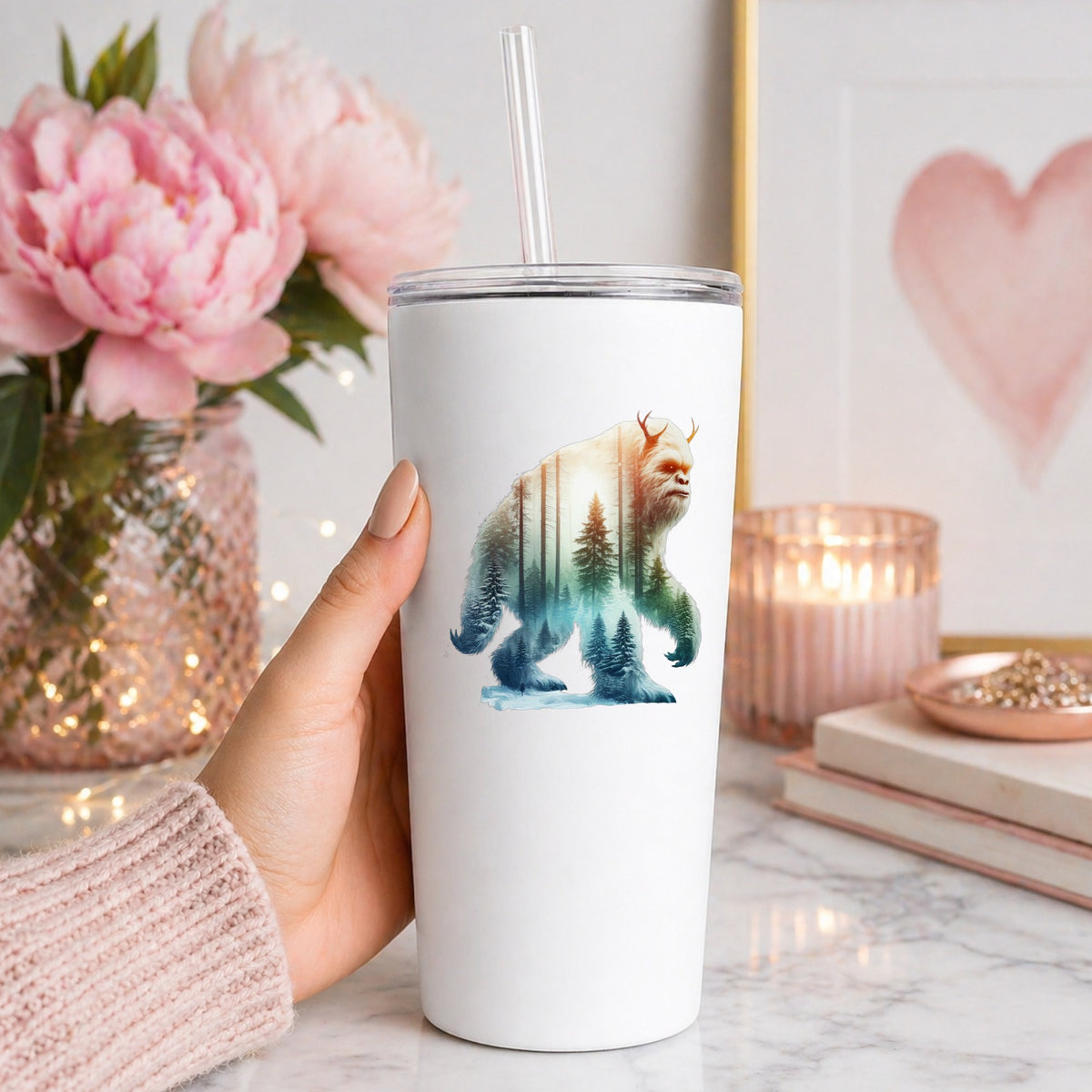 Walking Sasquatch UV DTF sticker applied to a white straw tumbler beside pink peonies