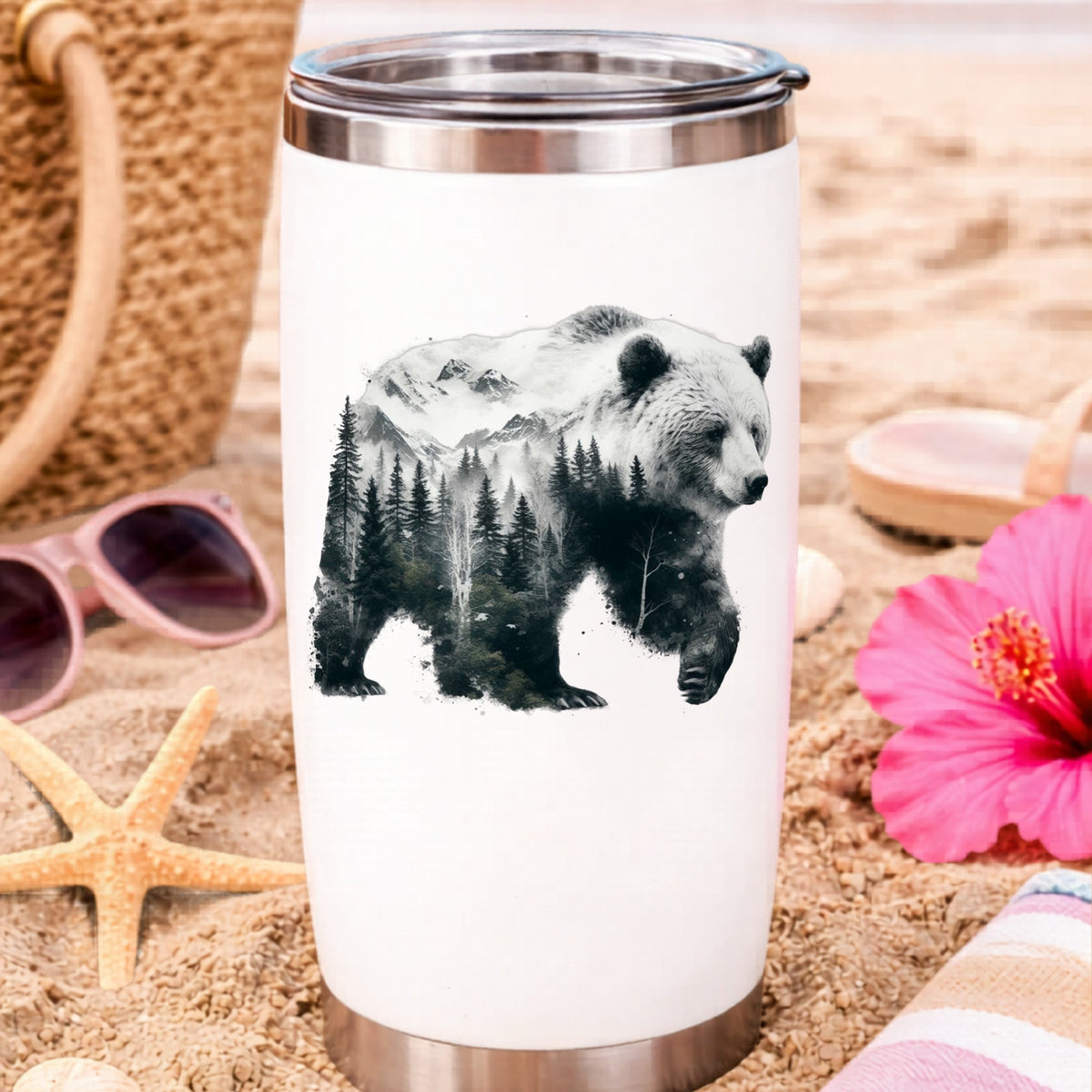 Mountain Bear UV DTF sticker applied to a white travel tumbler on beach sand
