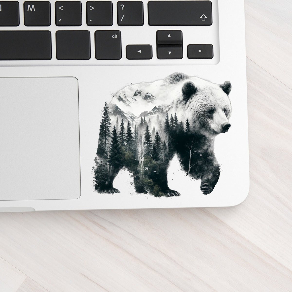Mountain Bear UV DTF sticker applied to a silver laptop beside the keyboard
