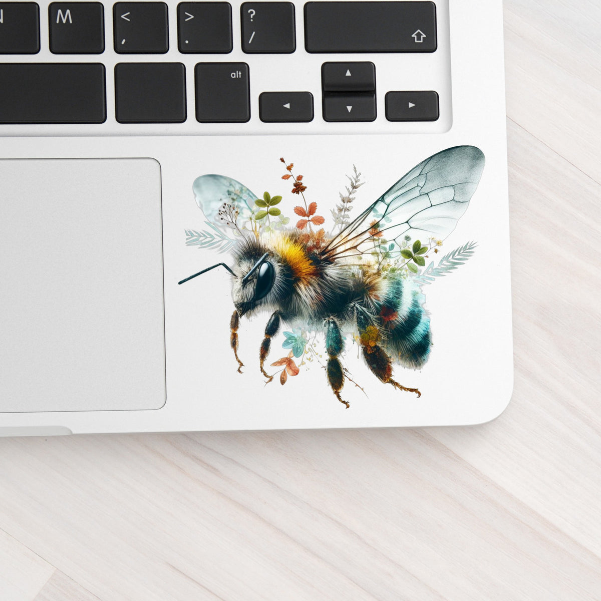 Botanical Bumblebee UV DTF sticker applied to a silver laptop beside the keyboard