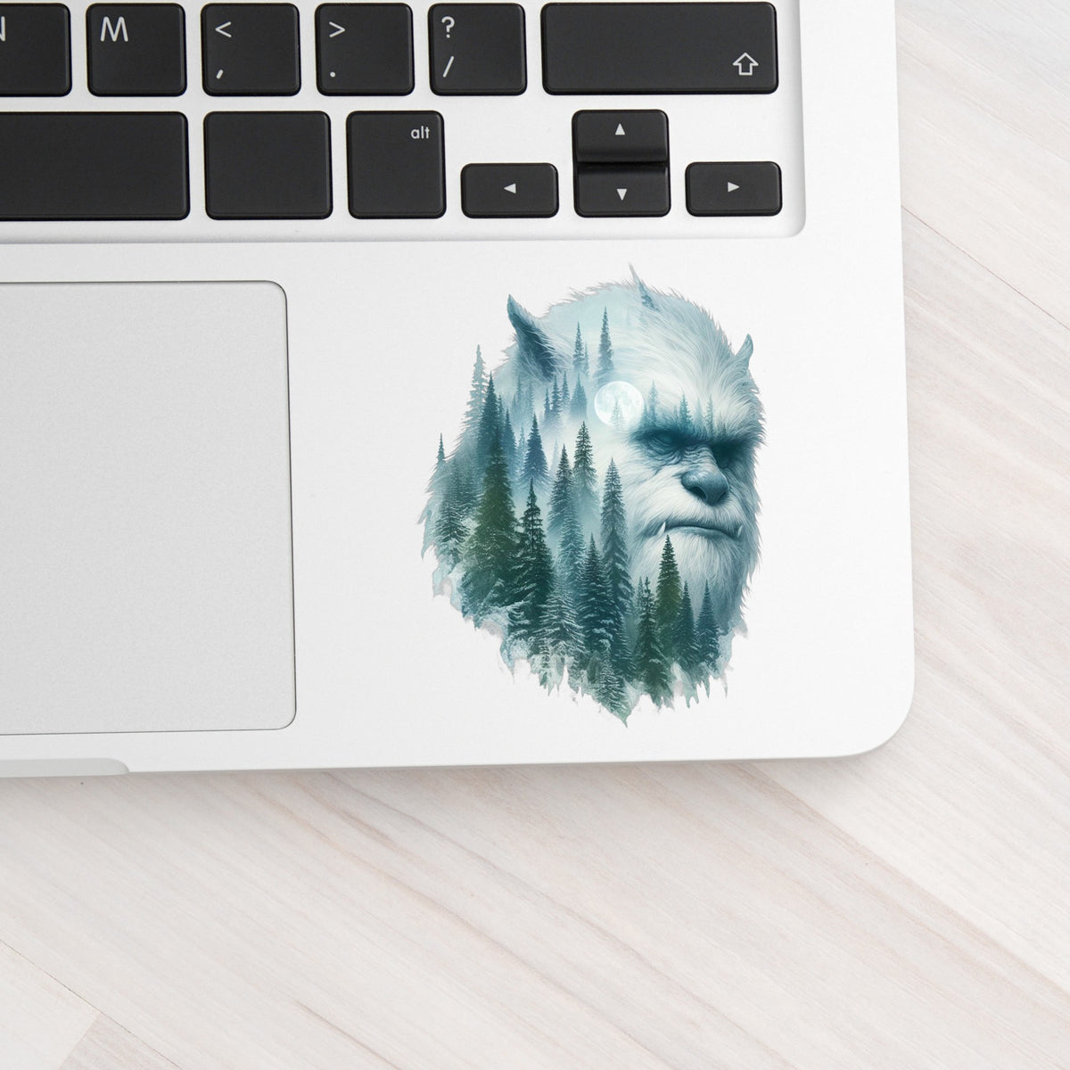 Full Moon Sasquatch UV DTF sticker applied to a silver laptop beside the keyboard