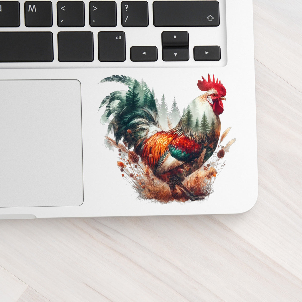 Colorful Rooster UV DTF sticker applied to a silver laptop beside the keyboard