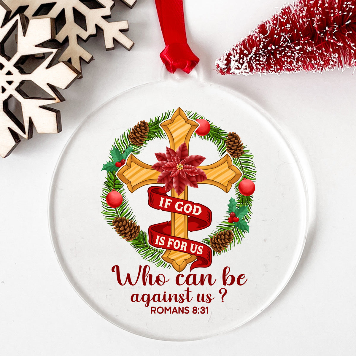 If God Is For Us Christmas Cross UV DTF sticker applied to a clear round acrylic ornament with a red ribbon