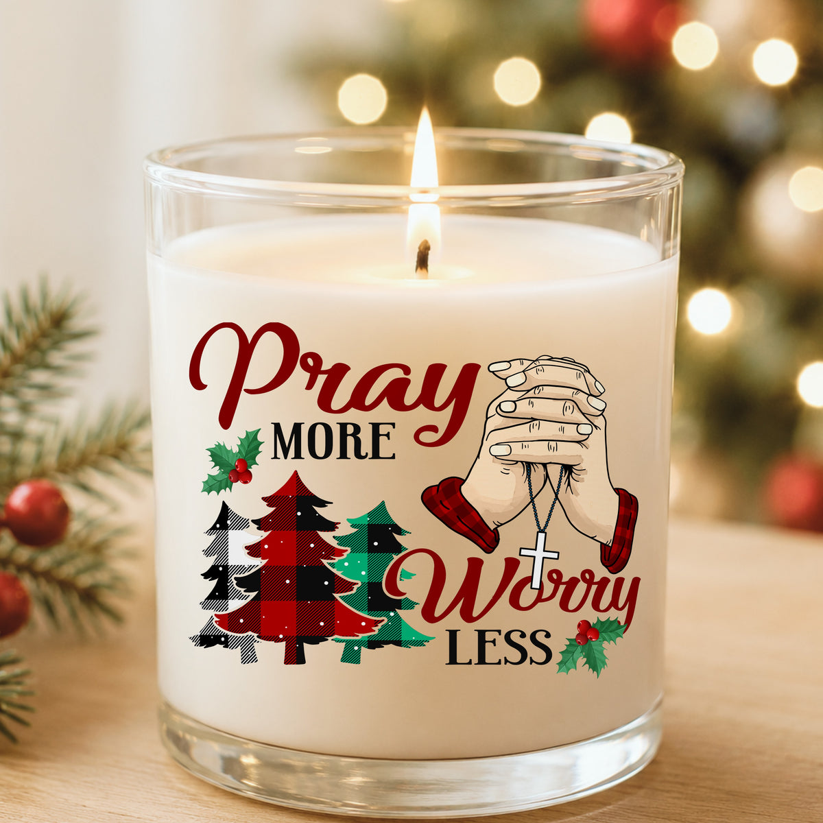 Pray More Worry Less Praying Hands UV DTF sticker applied to a white candle in a glass holder near Christmas lights