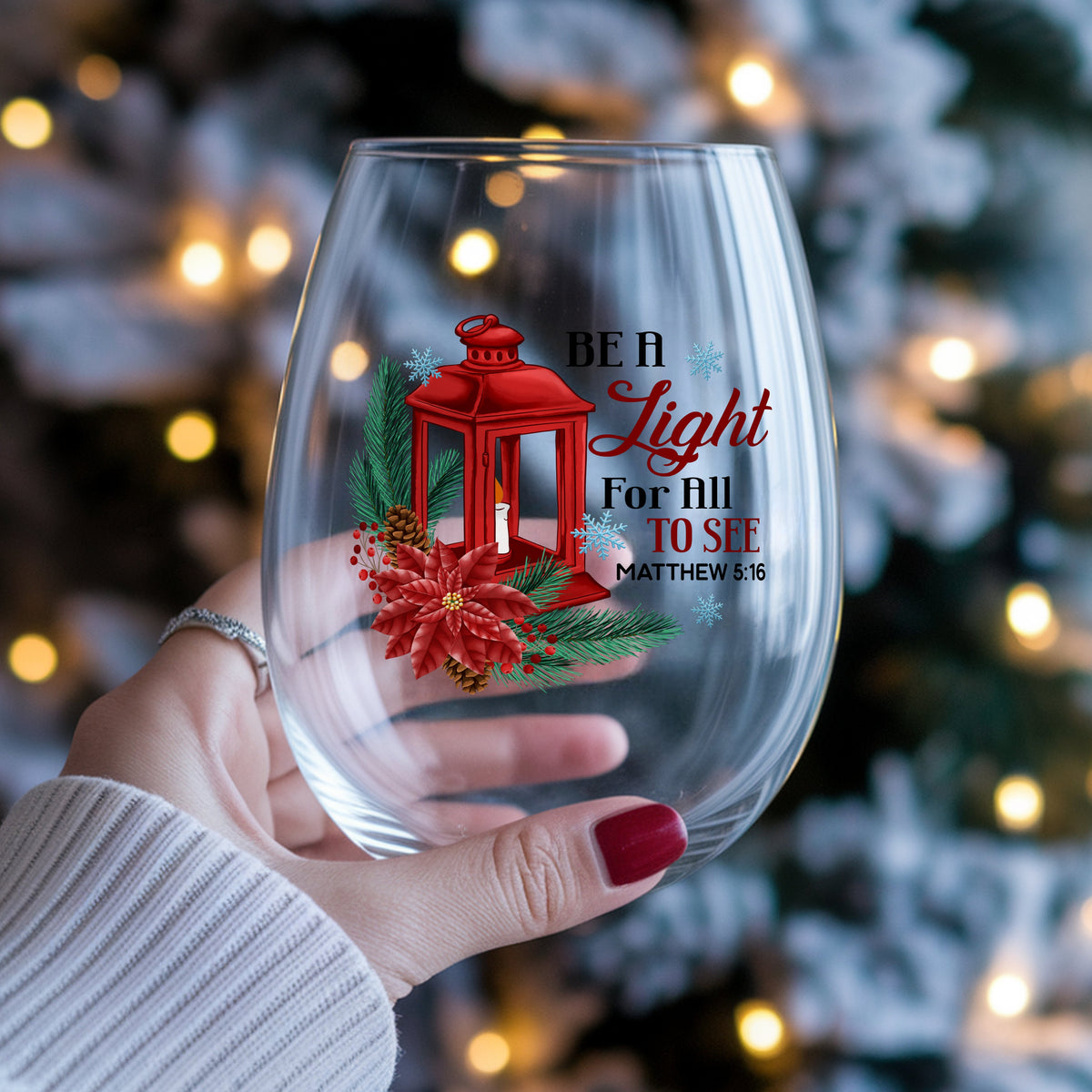 Be A Light Christmas Lantern UV DTF sticker applied to a stemless wine glass held in hand