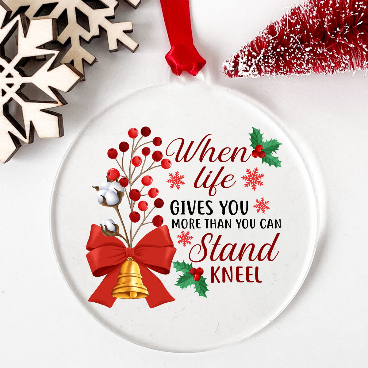 Kneel Faith Quote Red Bow UV DTF sticker applied to a clear round acrylic ornament with a red ribbon