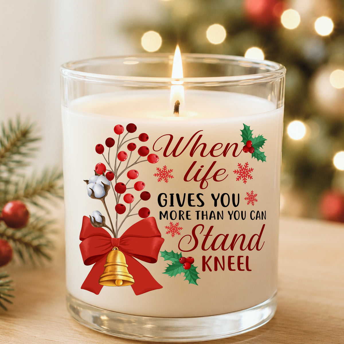 Kneel Faith Quote Red Bow UV DTF sticker applied to a white candle in a glass holder near Christmas lights