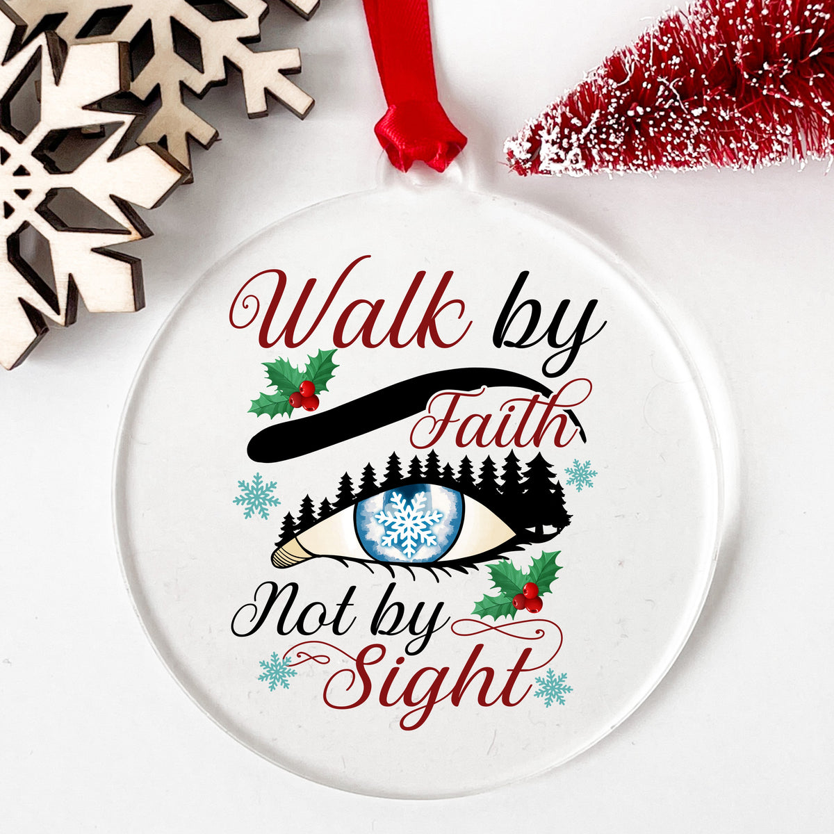 Walk By Faith Snowflake Eye UV DTF sticker applied to a clear round acrylic ornament with a red ribbon