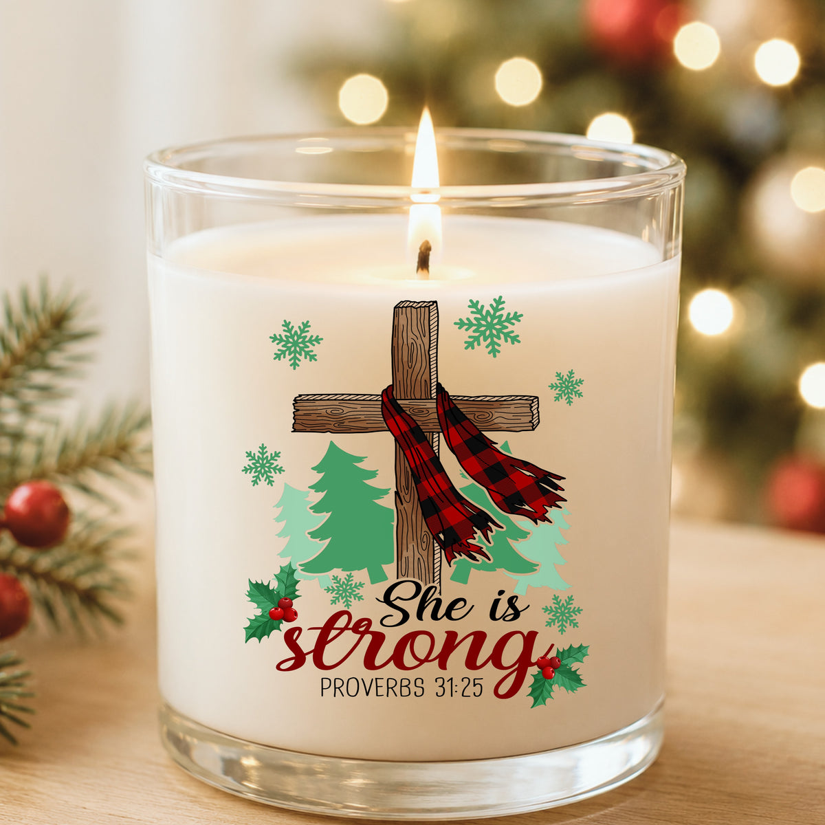She Is Strong Christmas Cross UV DTF sticker applied to a white candle in a glass holder near Christmas lights