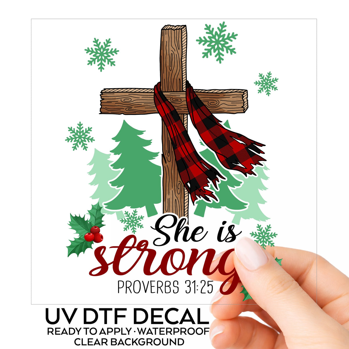 She Is Strong Christmas Cross UV DTF sticker on its backing card, held in hand