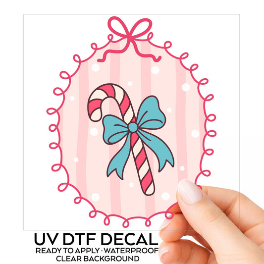 Coquette Candy Cane UV DTF sticker on its backing card, held in hand