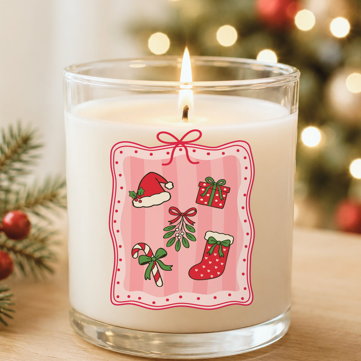 Coquette Christmas Icons Pink Frame UV DTF sticker applied to a white candle in a glass holder near Christmas lights