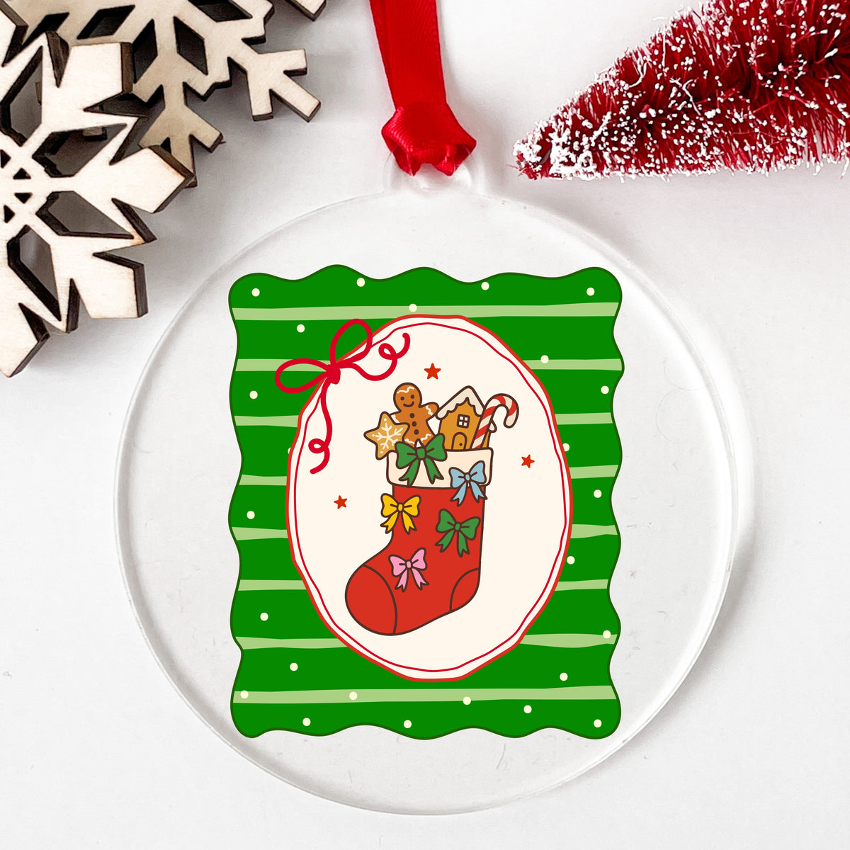 Coquette Gingerbread Stocking UV DTF sticker applied to a clear round acrylic ornament with a red ribbon