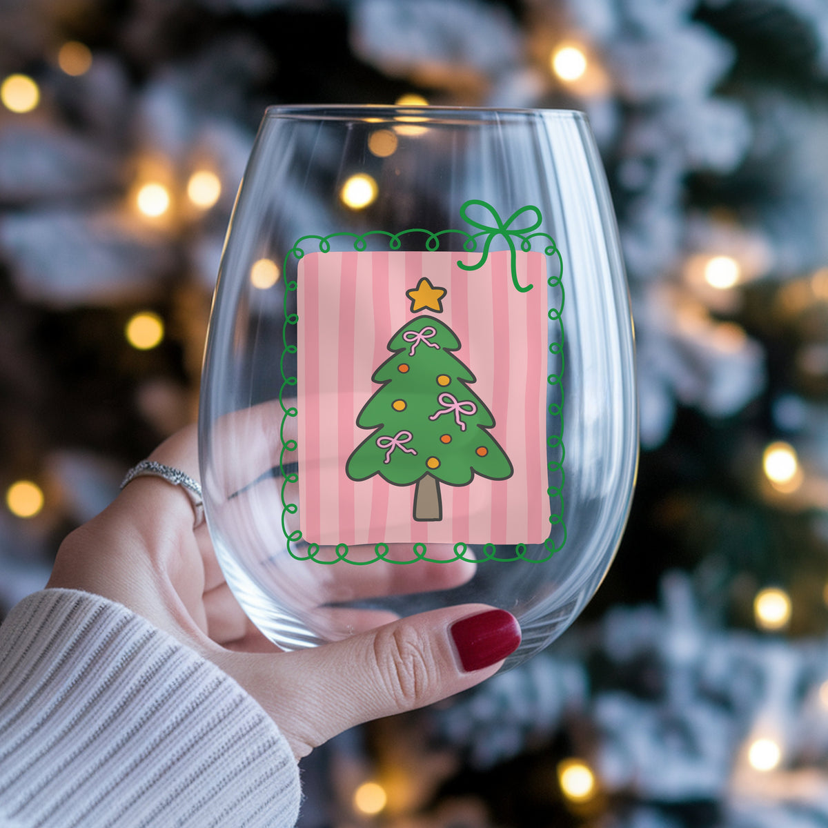 Coquette Pink Bow Christmas Tree UV DTF sticker applied to a stemless wine glass held in hand