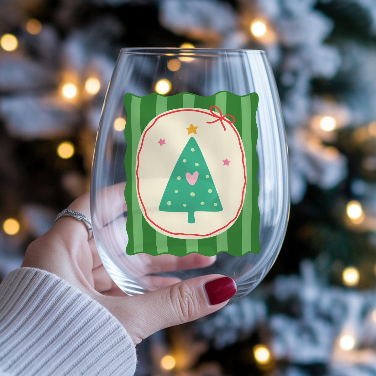 Coquette Teal Heart Christmas Tree UV DTF sticker applied to a stemless wine glass held in hand