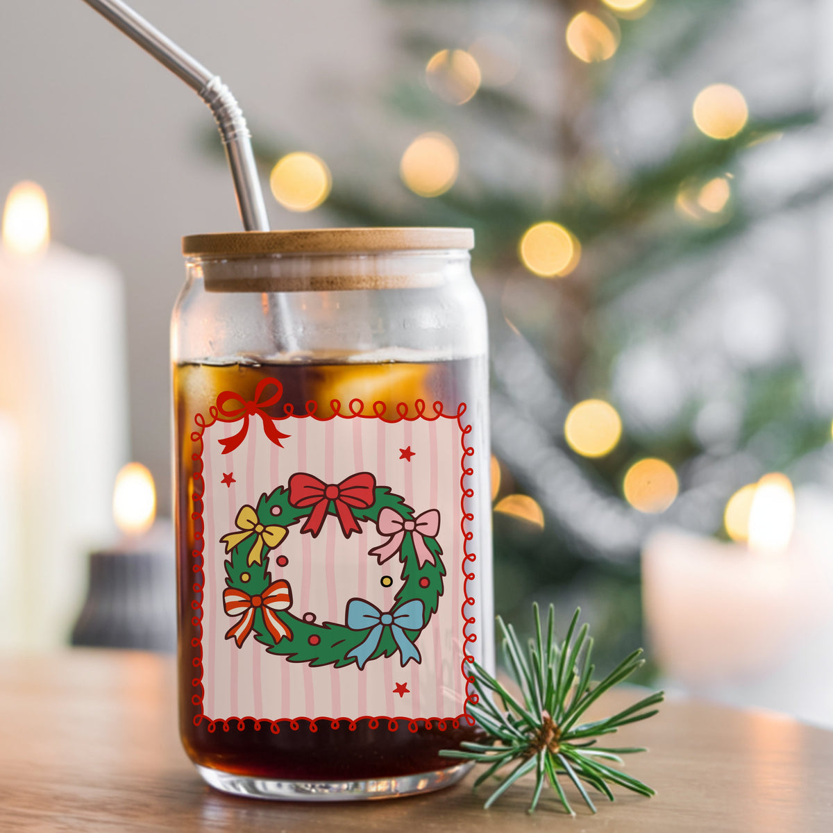 Coquette Bow Christmas Wreath UV DTF sticker applied to a glass can cup of iced coffee with a straw