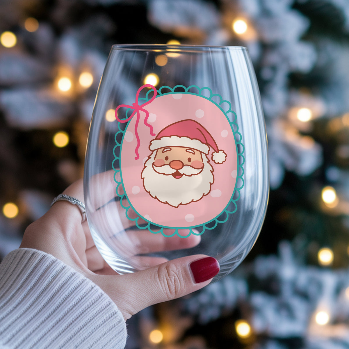 Coquette Pink Santa Claus Face UV DTF sticker applied to a stemless wine glass held in hand