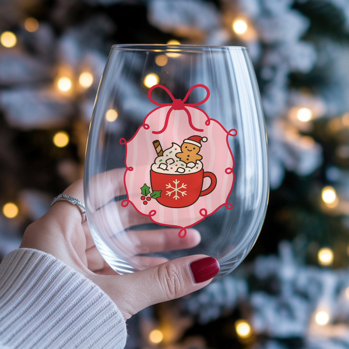 Coquette Gingerbread Hot Cocoa UV DTF sticker applied to a stemless wine glass held in hand
