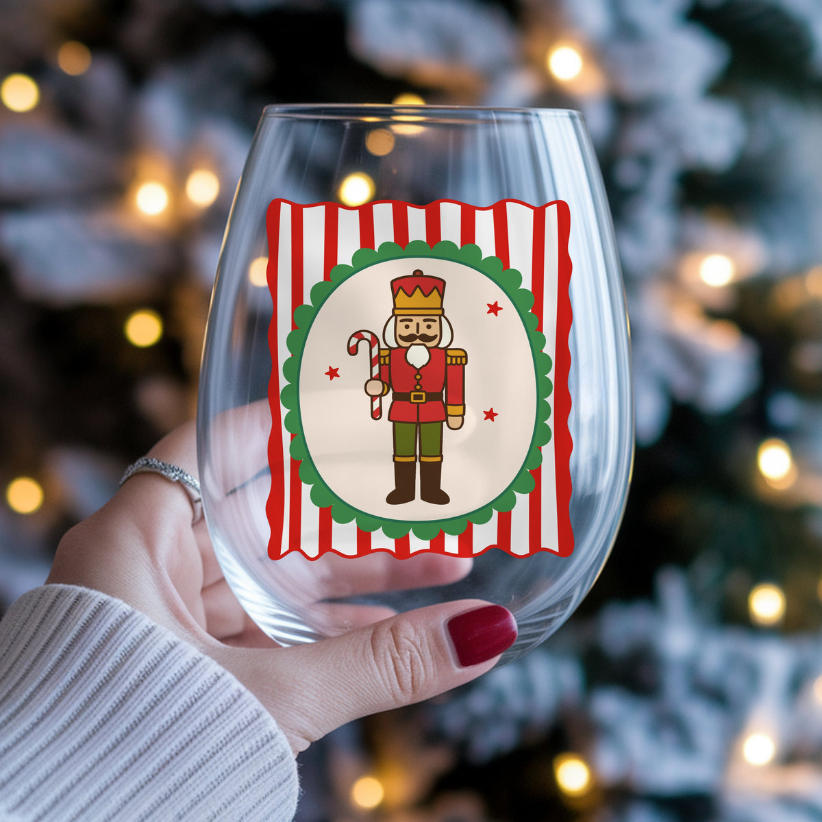 Coquette Nutcracker Soldier UV DTF sticker applied to a stemless wine glass held in hand