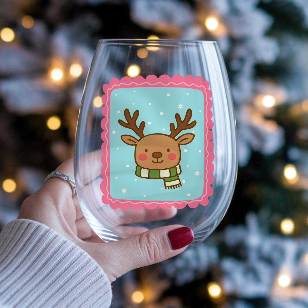 Coquette Reindeer Face UV DTF sticker applied to a stemless wine glass held in hand