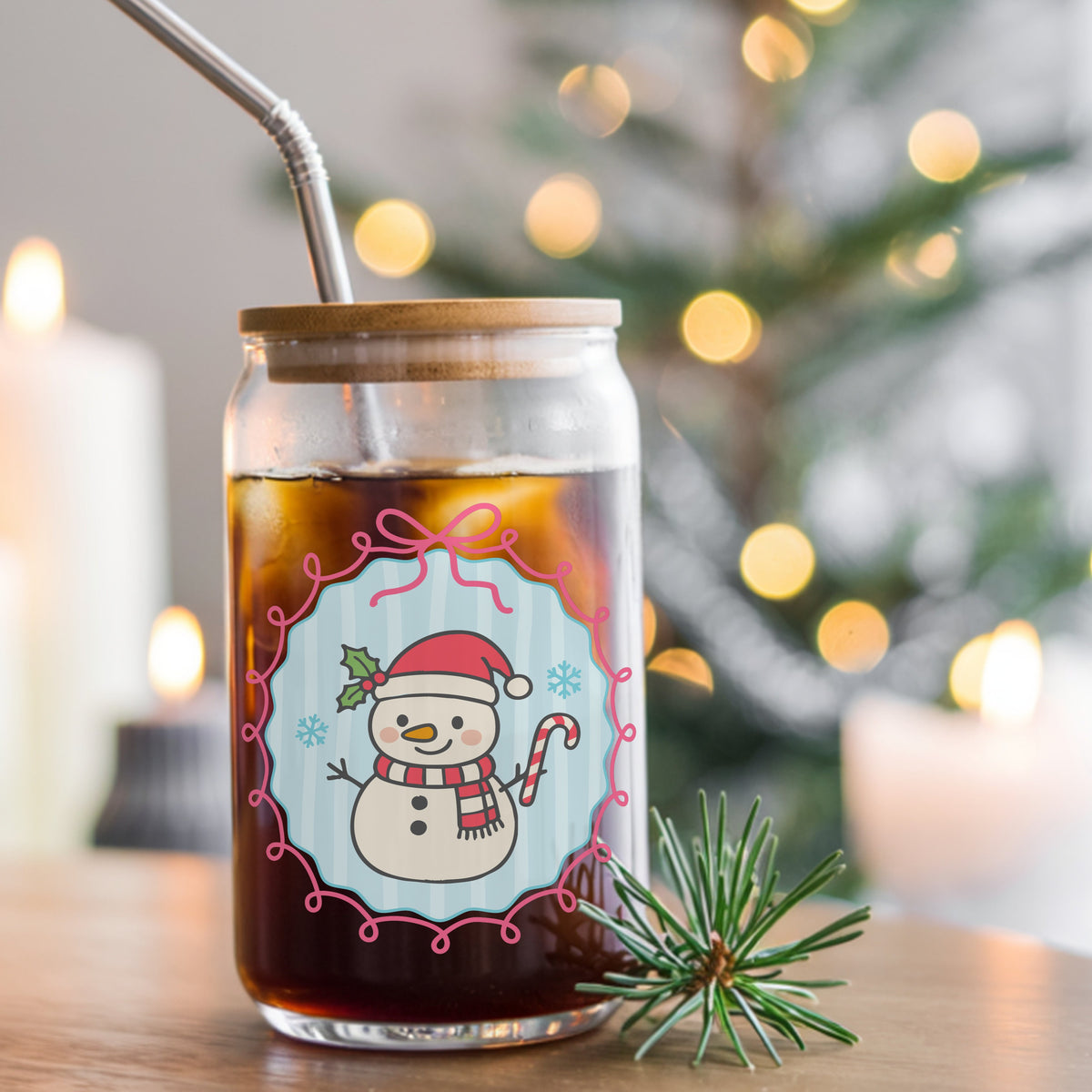 Coquette Snowman Candy Cane UV DTF sticker applied to a glass can cup of iced coffee with a straw