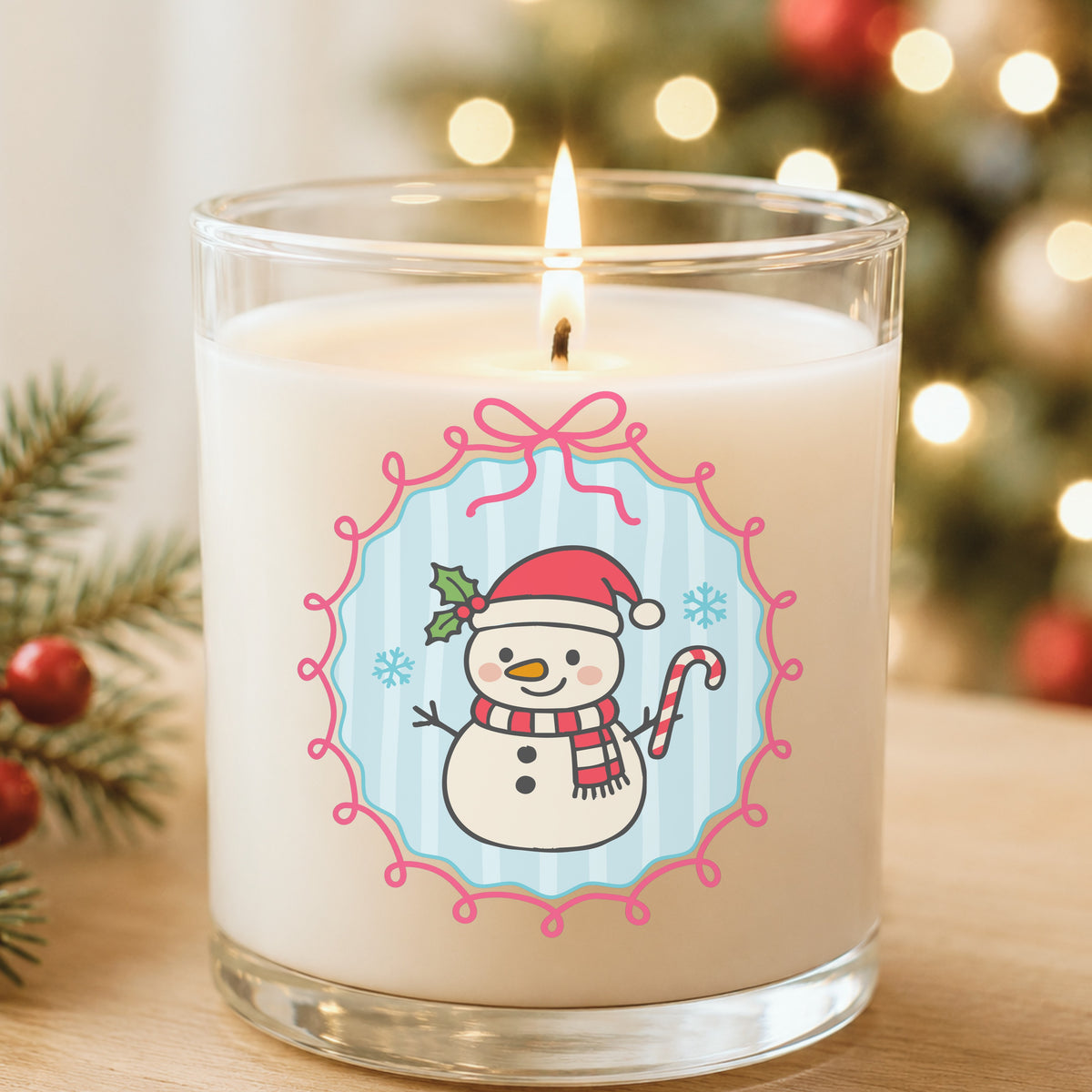 Coquette Snowman Candy Cane UV DTF sticker applied to a white candle in a glass holder near Christmas lights