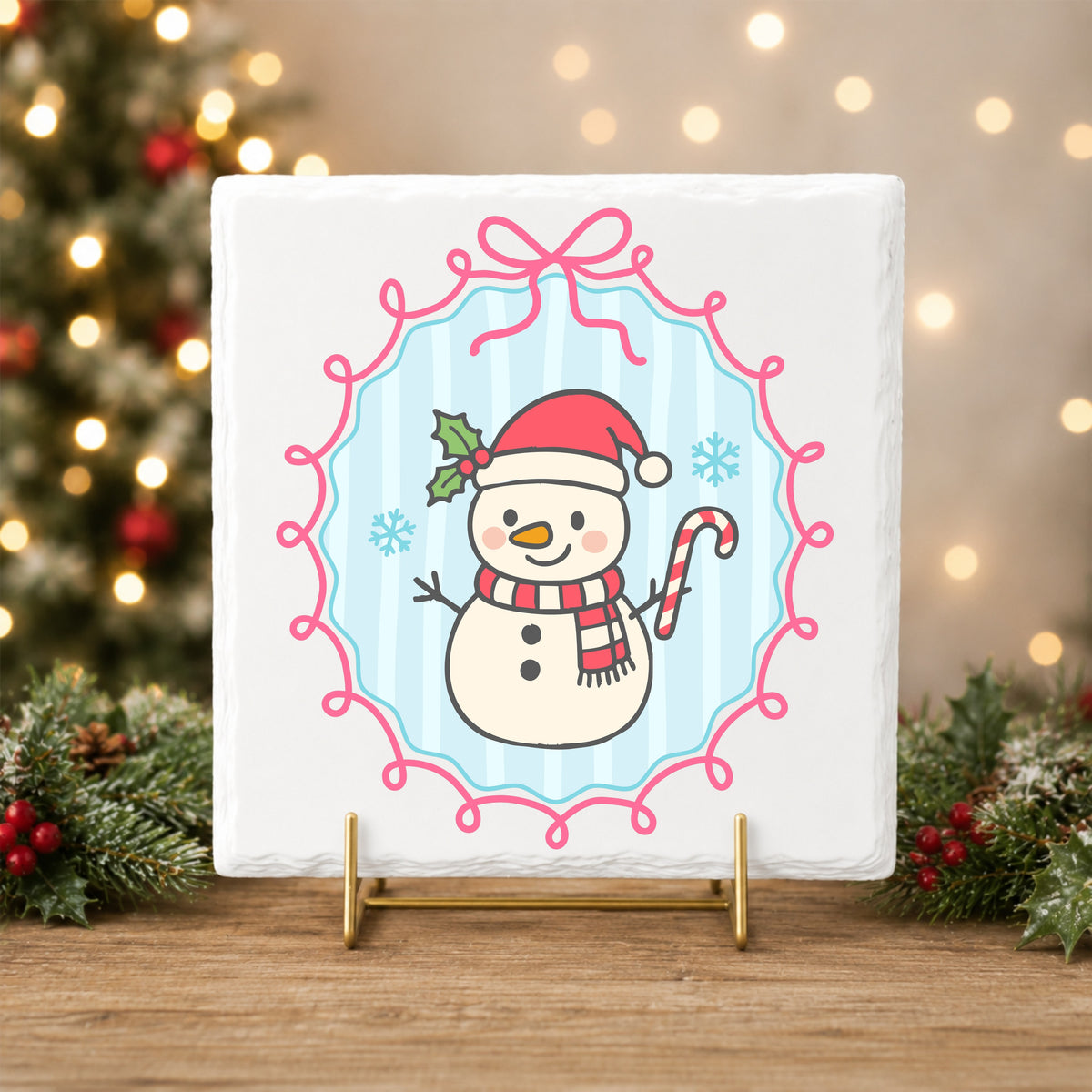 Coquette Snowman Candy Cane UV DTF sticker applied to a white tile on a gold stand