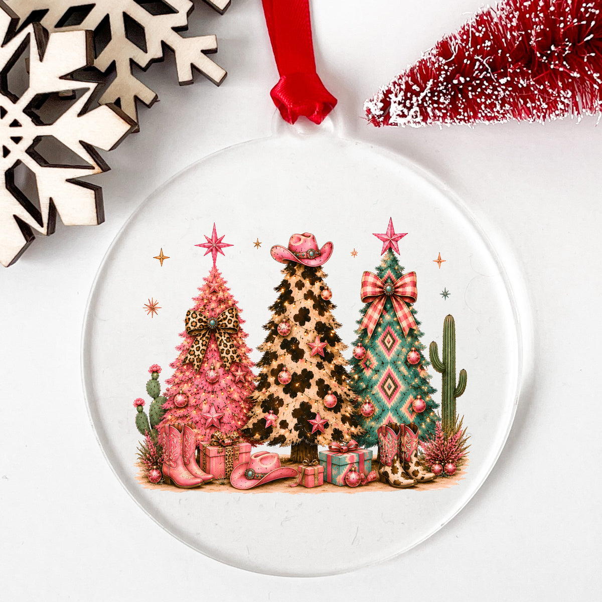 Western Leopard Christmas Trees UV DTF sticker applied to a clear round acrylic ornament with a red ribbon