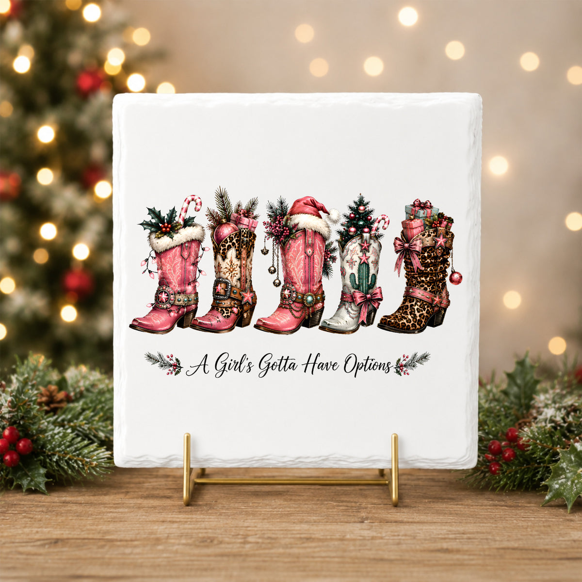 A Girls Gotta Have Options Christmas Boots UV DTF sticker applied to a white tile on a gold stand