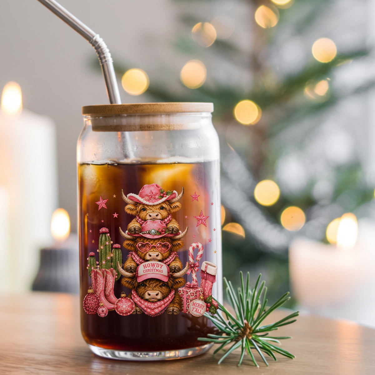 Stacked Highland Cows Howdy Christmas UV DTF sticker applied to a glass can cup of iced coffee with a straw