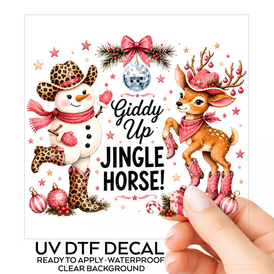 Giddy Up Jingle Horse Snowman Reindeer UV DTF sticker on its backing card, held in hand