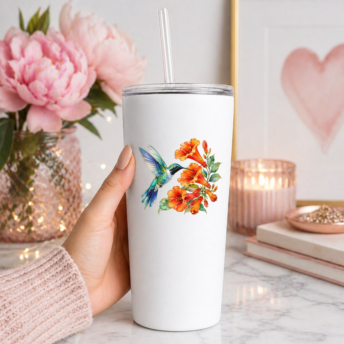 Blue Hummingbird Trumpet Flowers UV DTF sticker applied to a white straw tumbler beside pink peonies