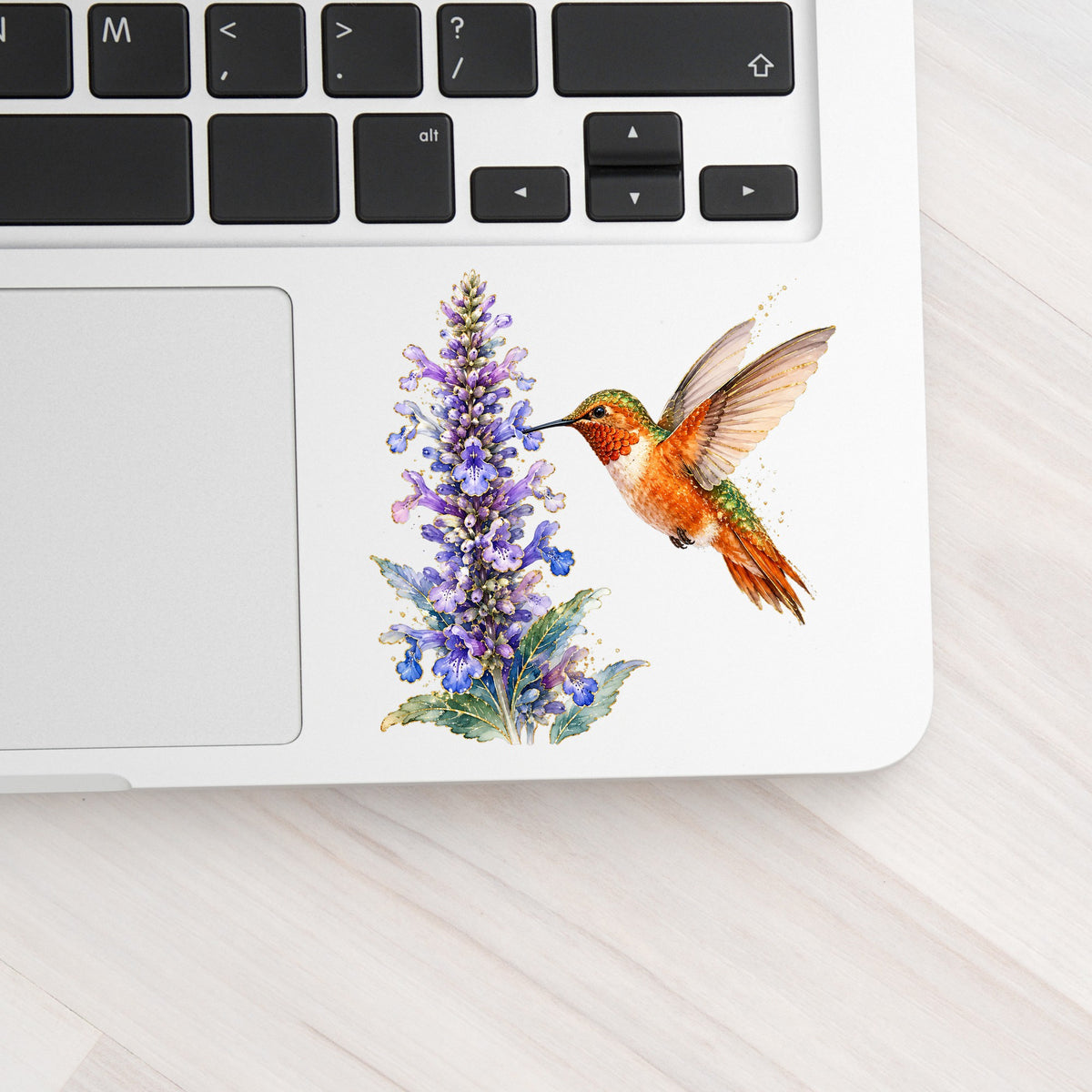 Rufous Hummingbird Purple Flowers UV DTF sticker applied to a silver laptop beside the keyboard