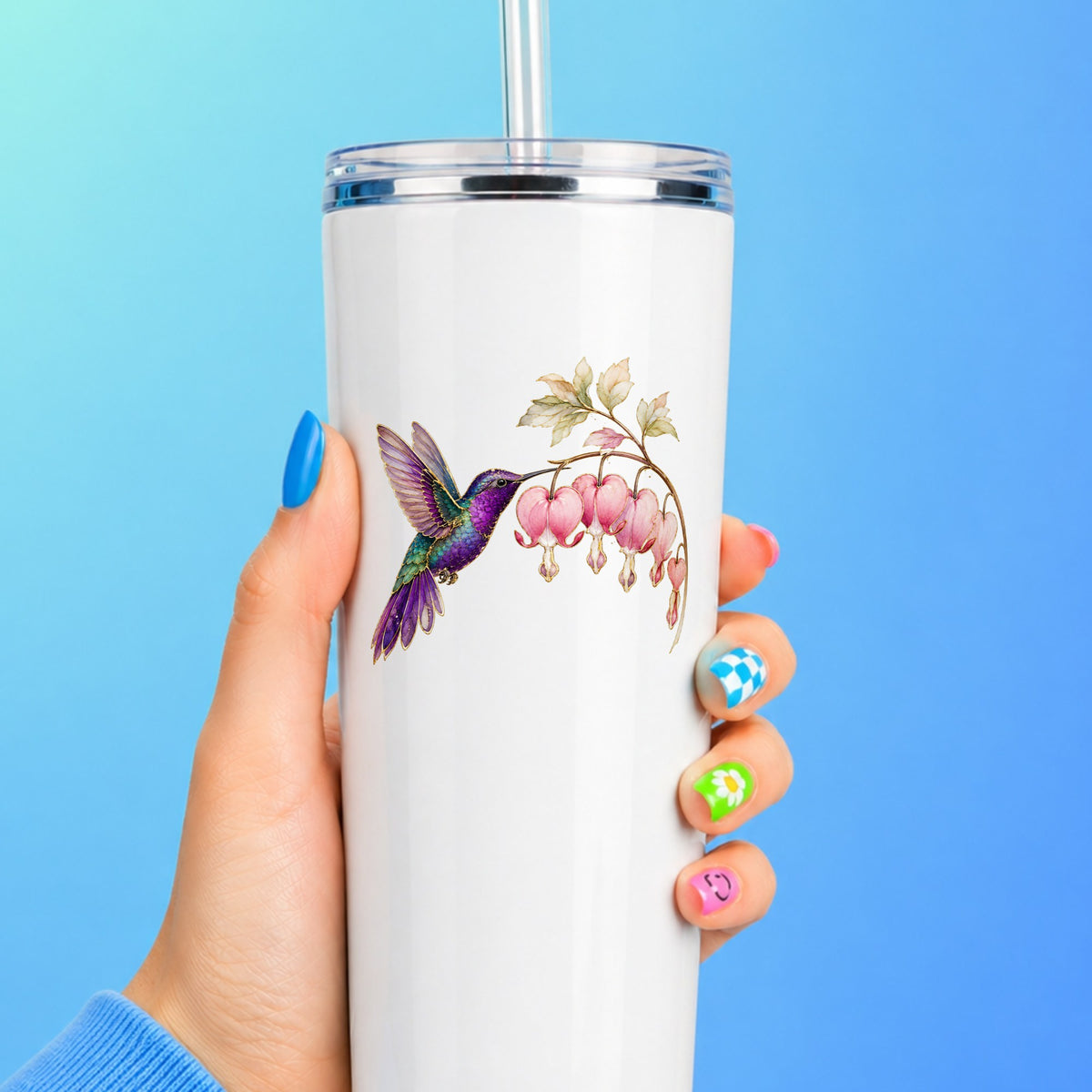Purple Hummingbird Bleeding Heart UV DTF sticker applied to a white straw tumbler on a blue background