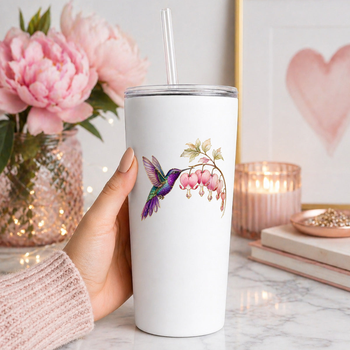 Purple Hummingbird Bleeding Heart UV DTF sticker applied to a white straw tumbler beside pink peonies