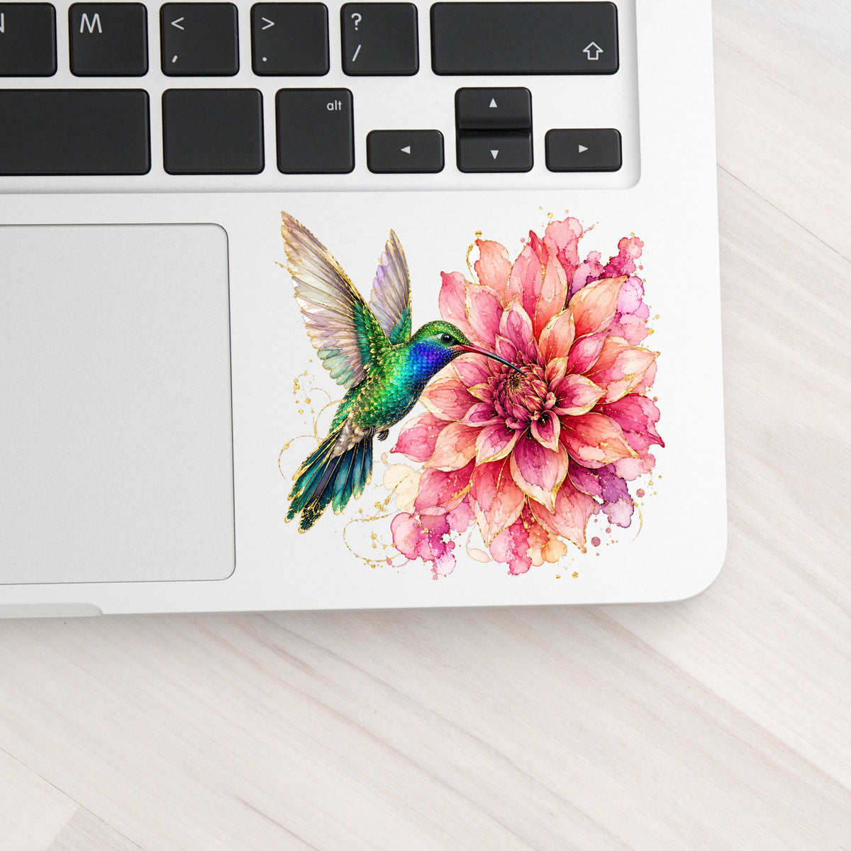 Hummingbird Pink Dahlia UV DTF sticker applied to a silver laptop beside the keyboard