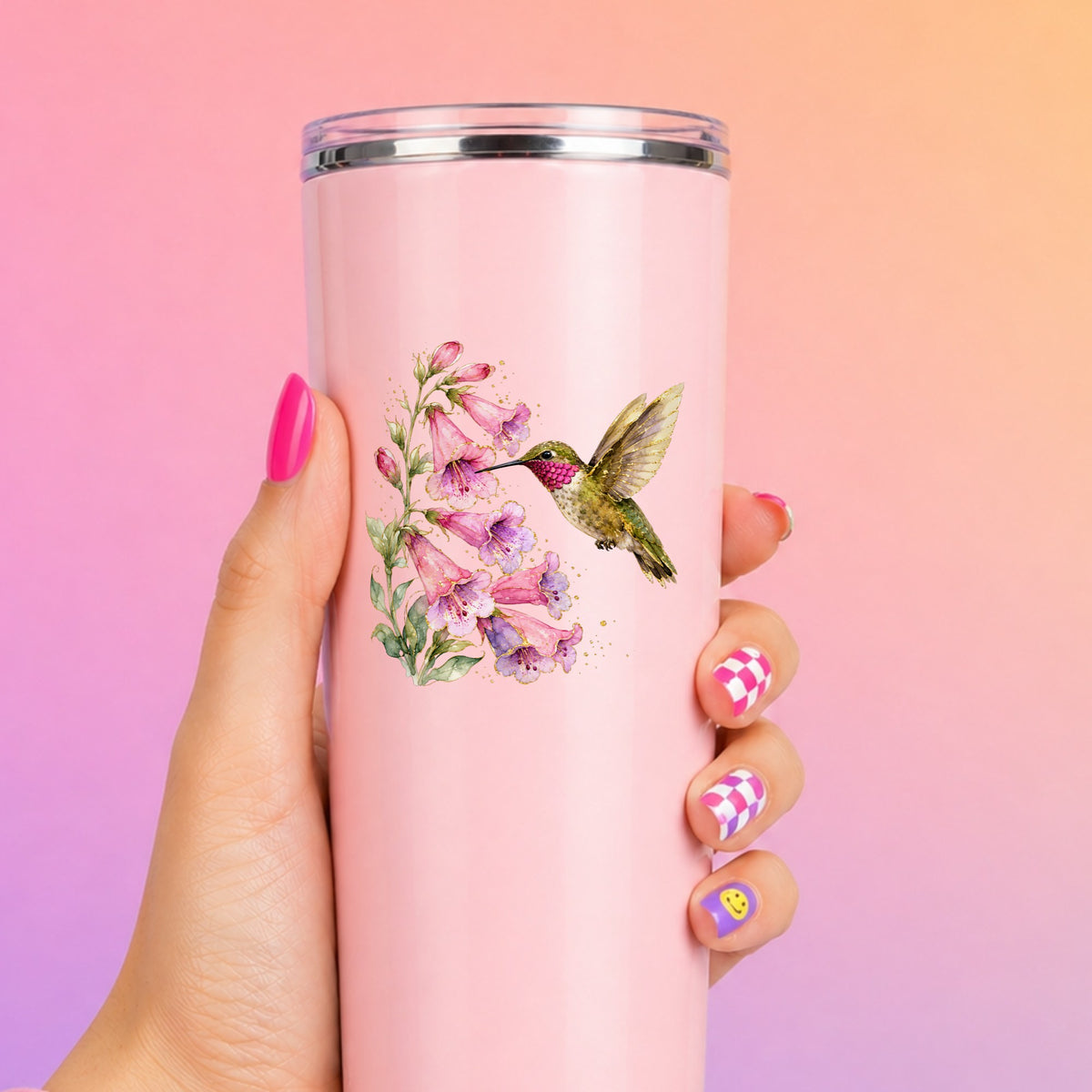 Ruby Throated Hummingbird Pink Bells UV DTF sticker applied to a tall pink tumbler on a pink and orange background